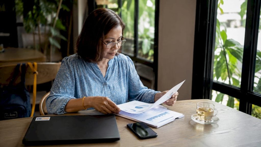 Seller reviewing international business documents at desk