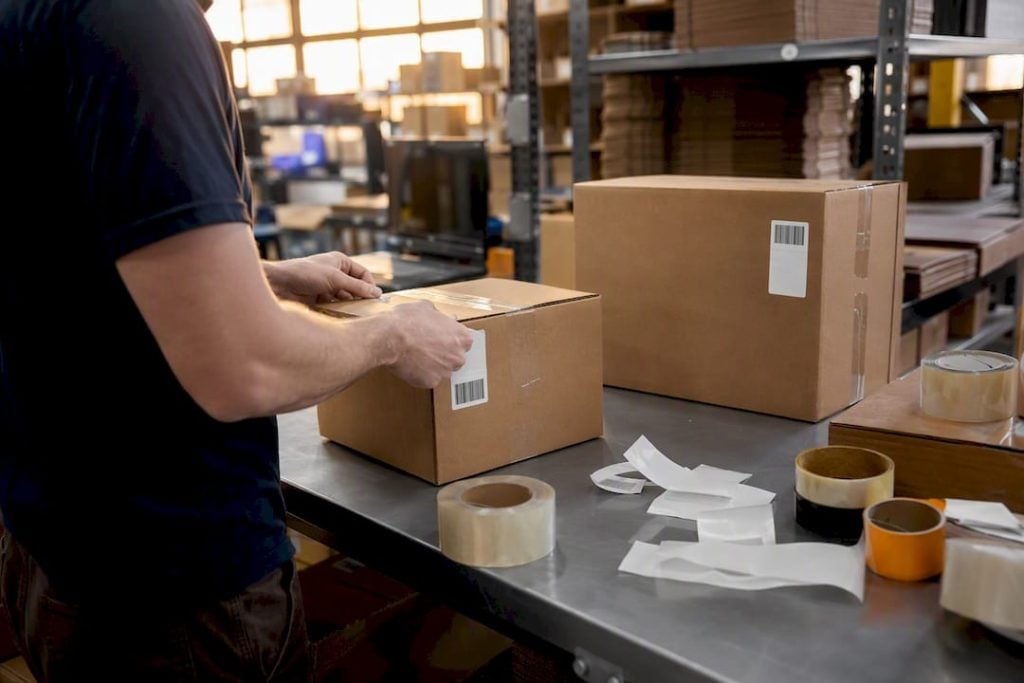 Hands applying labels in prep warehouse